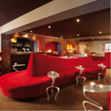Bacardi Lounge mit Loungemöbeln, Tischen und Bar im Hintergrund