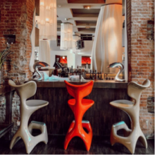 Drei Barstühle stehen an der Yakshi's Bar mit Blick auf das east Restaurant