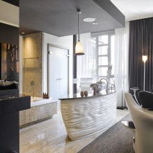 Open bathroom in the hotel room with bathtub, vanity and wardrobe in the background