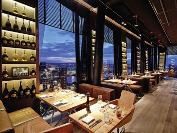 Covered window seats in the clouds restaurant with a view of the evening sky